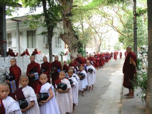Monks lining up with food bowls
