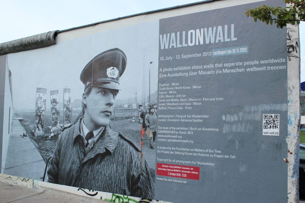 Poster on the Berlin Wall advertising an exhibit on other walls.