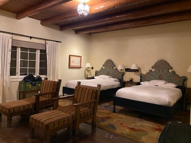 La Fonda beds with hand-painted headboards of green flowers with red centers.